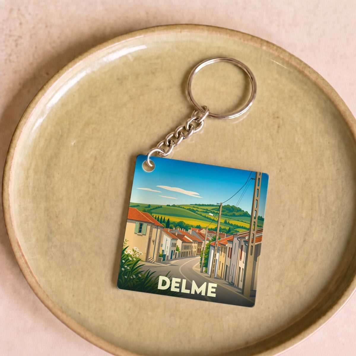Porte-clés souvenir de la ville de Delme avec une illustration stylisée.