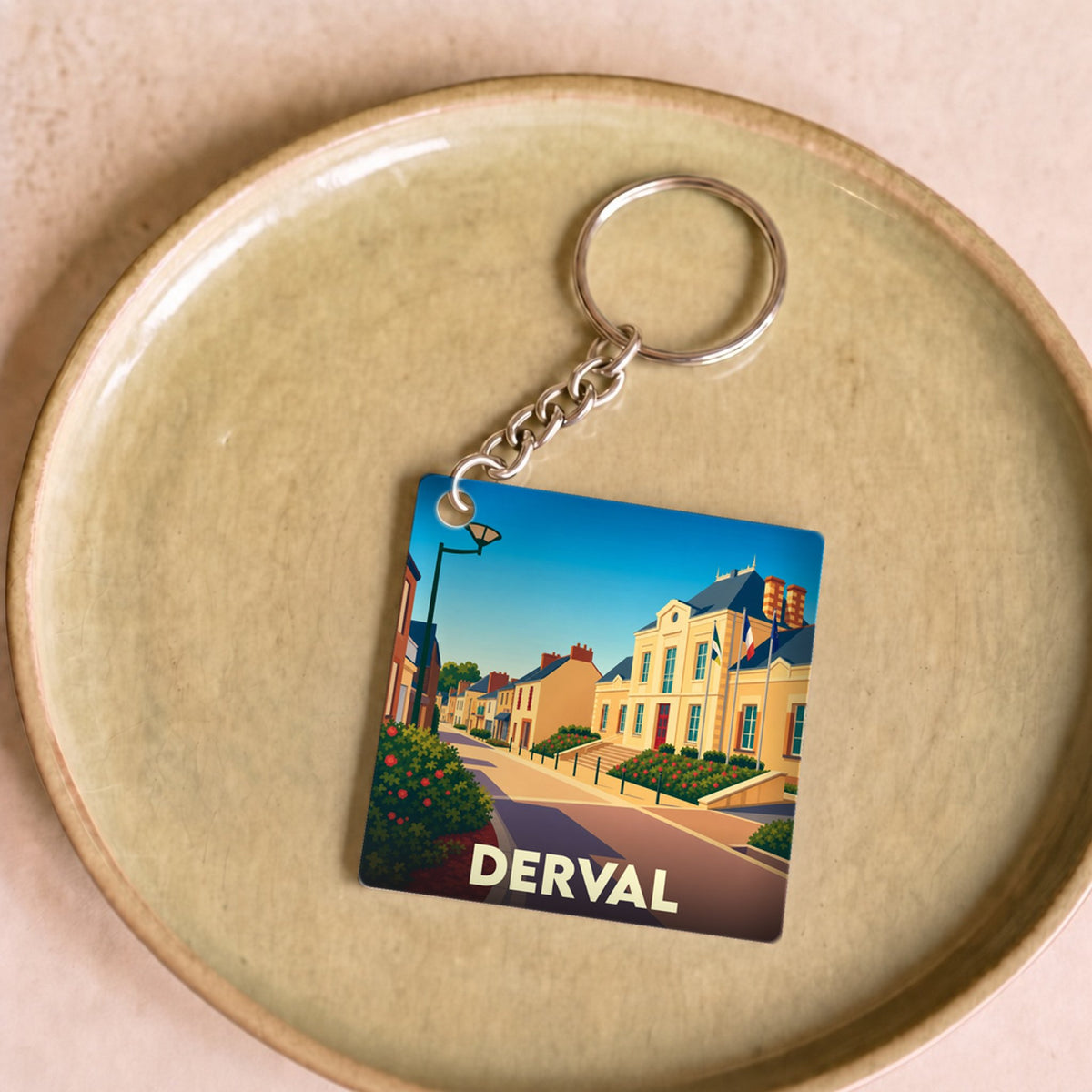 Porte-clés souvenir de la ville de Derval avec une illustration stylisée.