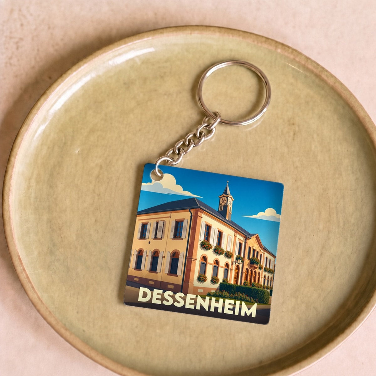 Porte-clés souvenir de la ville de Dessenheim avec une illustration stylisée.