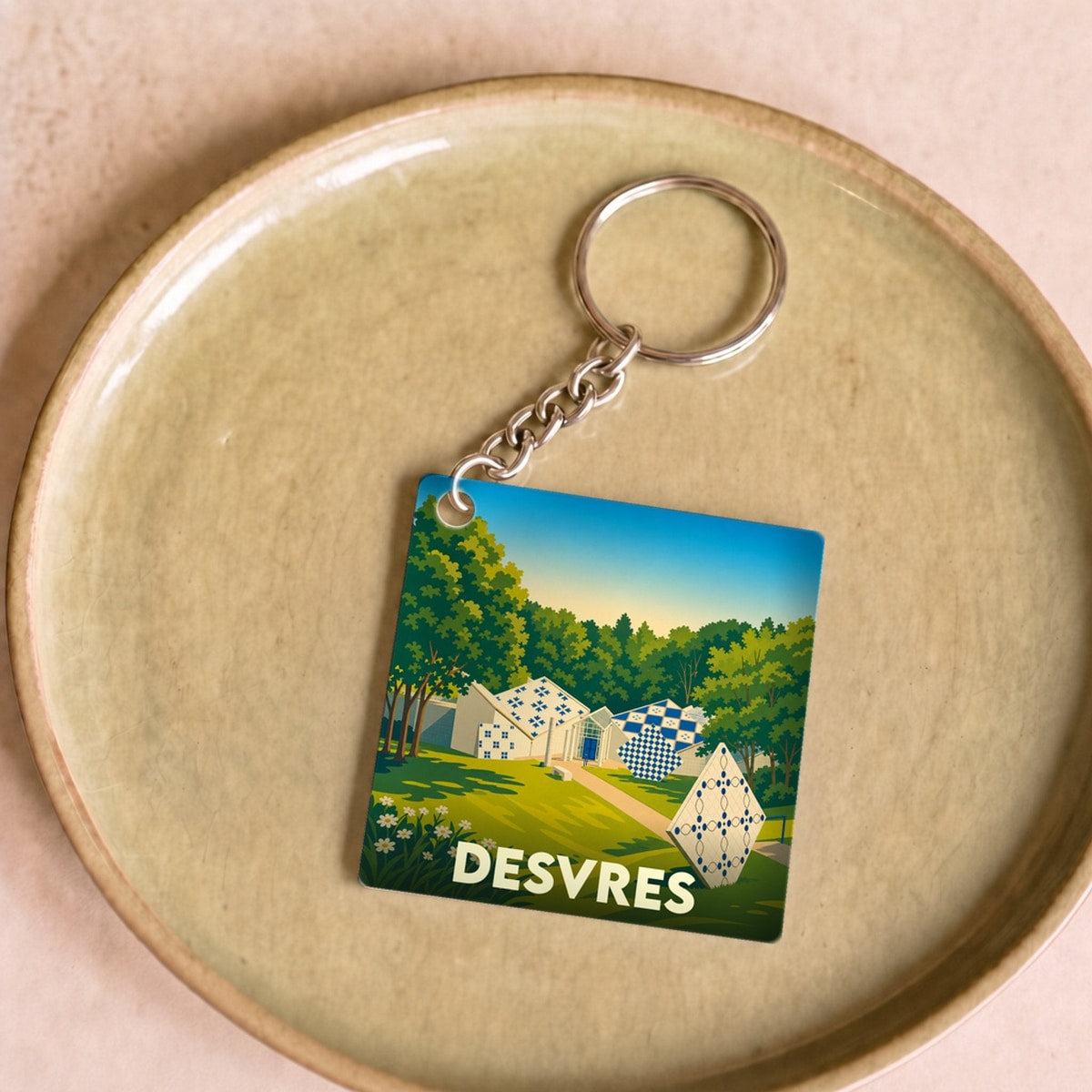 Porte-clés souvenir de la ville de Desvres avec une illustration colorée et stylisée.