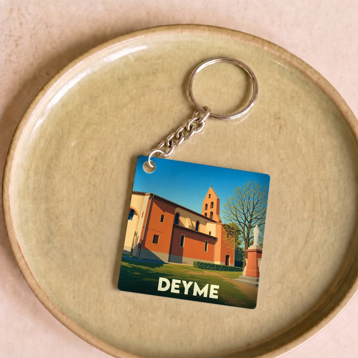 Porte-clés souvenir de la ville de Deyme avec une illustration stylisée de son église.