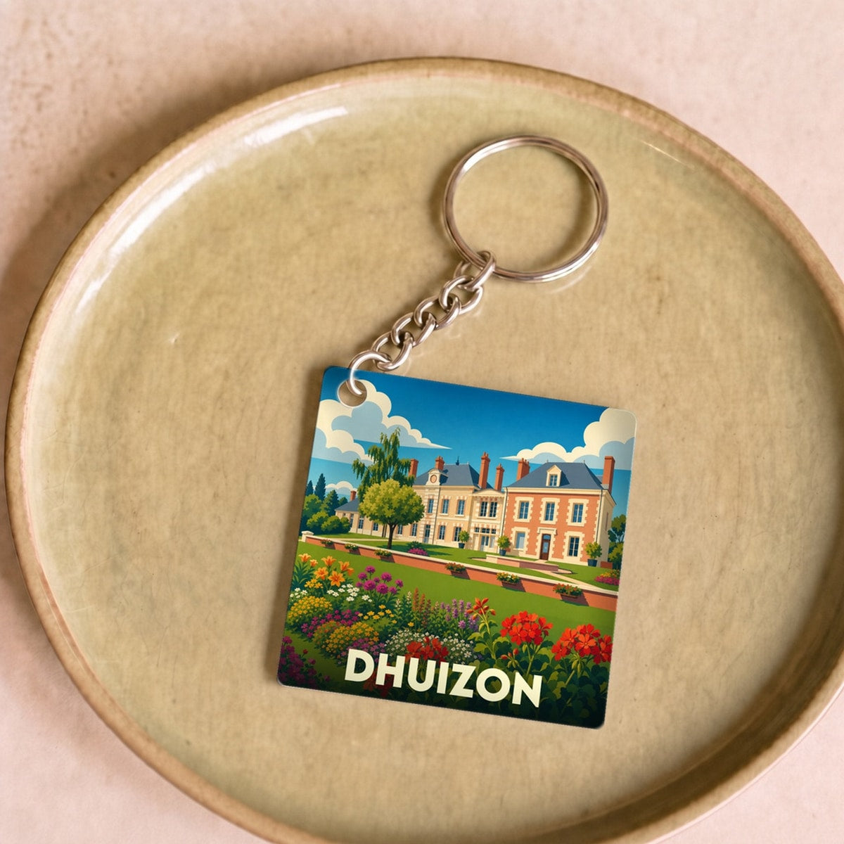 Porte-clés souvenir de la ville de Dhuizon avec une illustration stylisée d'un château fleuri.