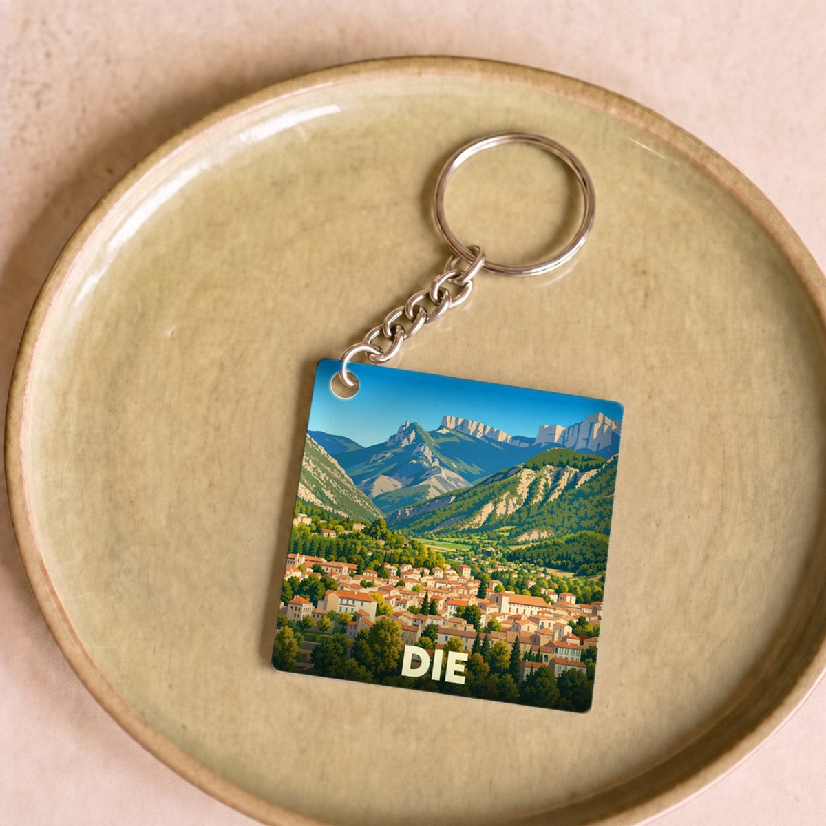 Porte-clés souvenir de la ville de Die avec une illustration stylisée d'un paysage montagneux.