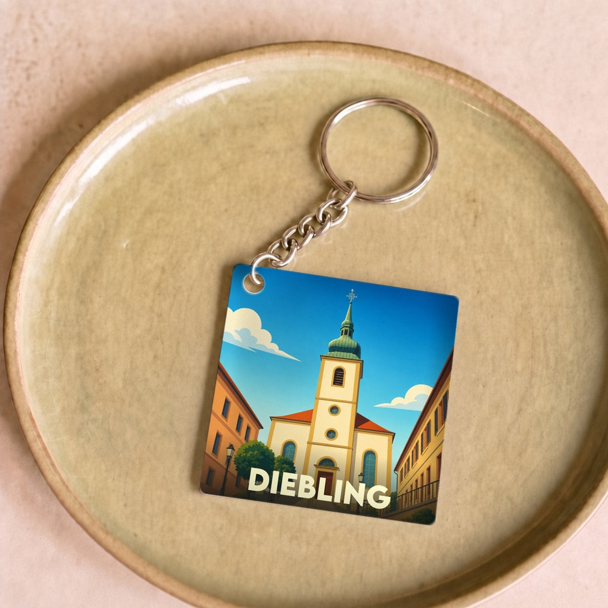 Porte-clés souvenir de la ville de Diebling avec une illustration stylisée de son église.