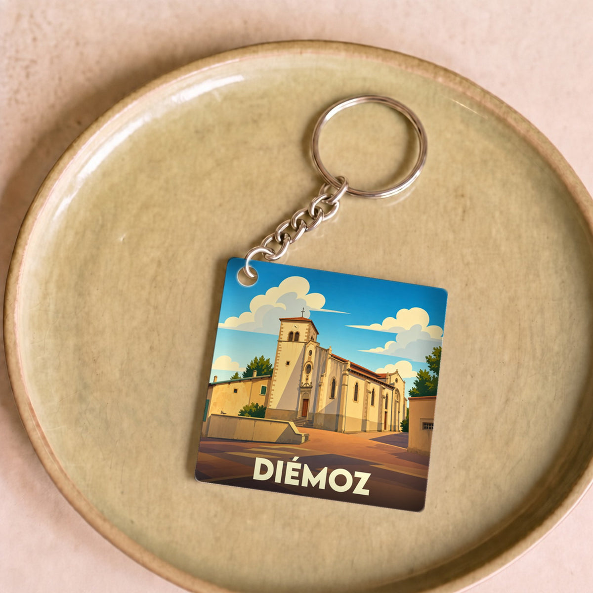 Porte-clés souvenir de la ville de Diémoz avec une illustration stylisée d'une église.