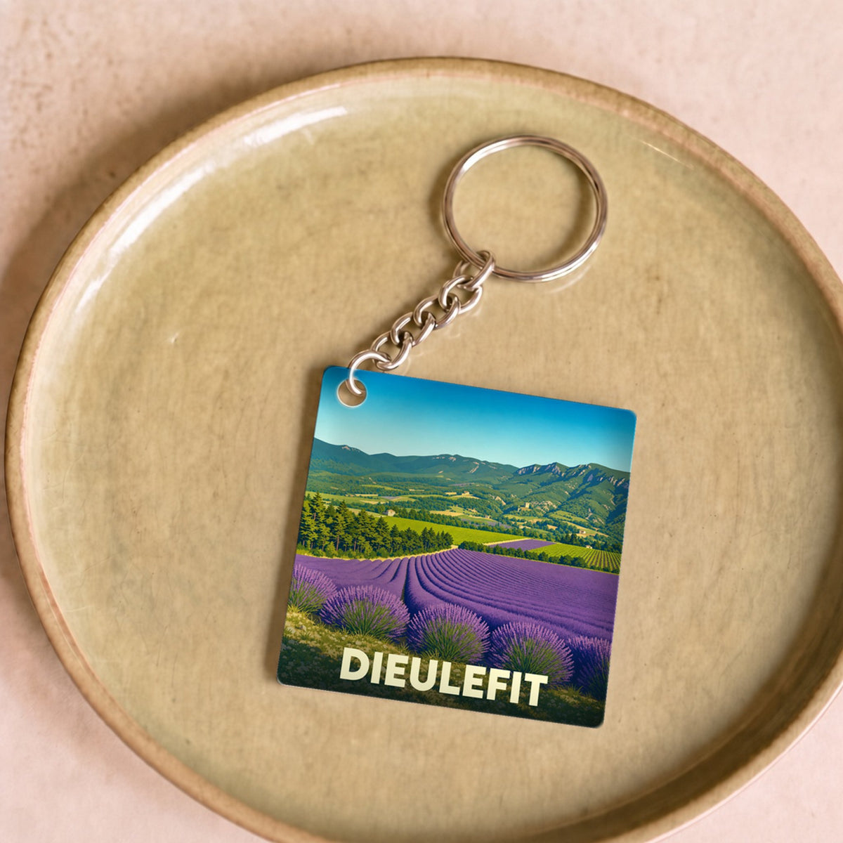 Porte-clés souvenir de la ville de Dieulefit avec une illustration de champs de lavande.