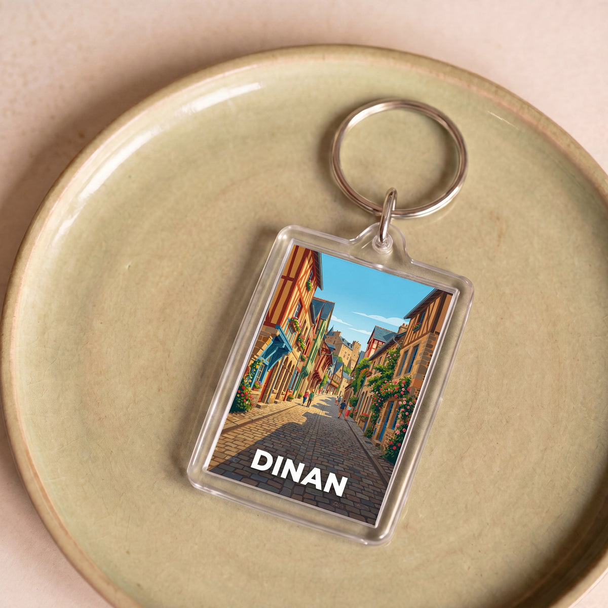 Porte-clés souvenir de la ville de Dinan avec une illustration stylisée.