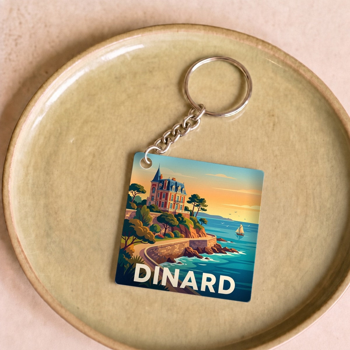 Porte-clés souvenir de la ville de Dinard avec une illustration stylisée.