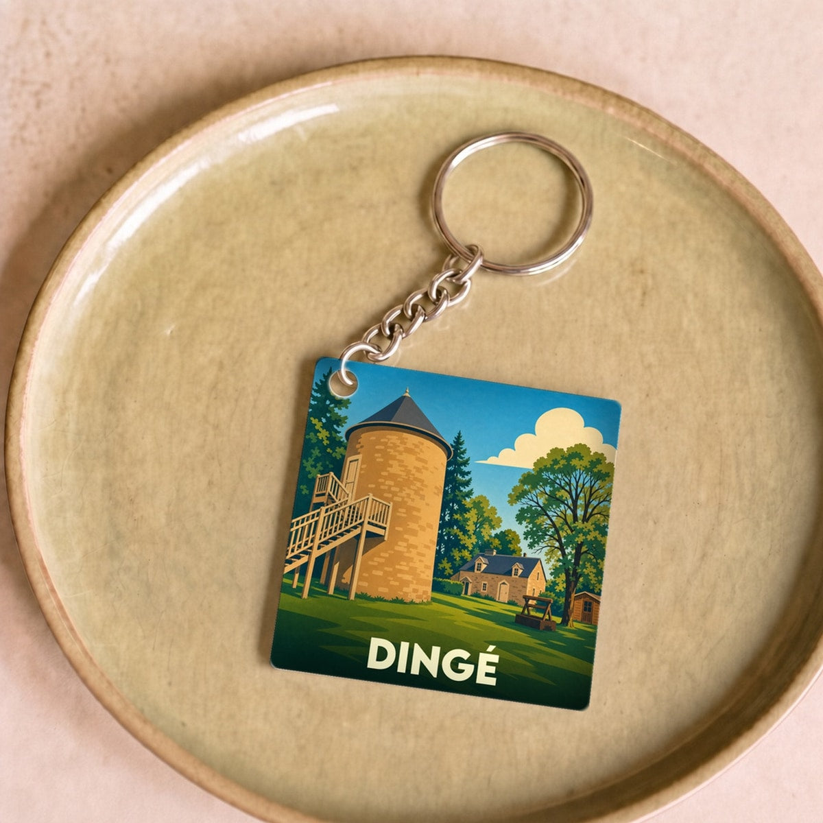 Porte-clés souvenir de la ville de Dingé avec une illustration stylisée.