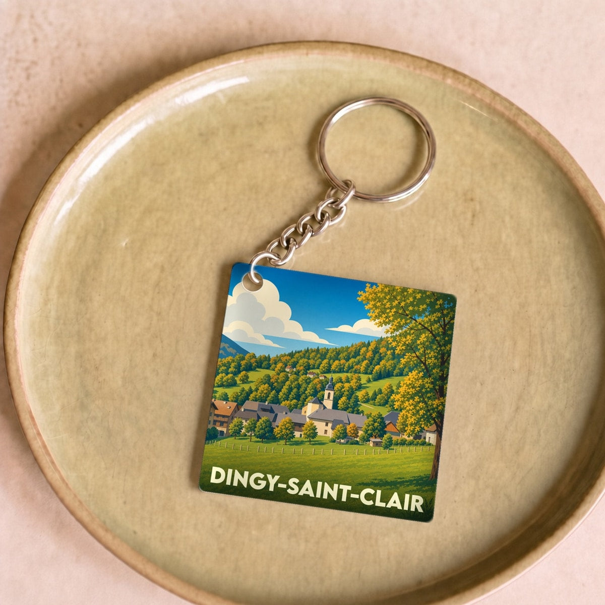 Porte-clés souvenir de la ville de Dingy-Saint-Clair avec une illustration stylisée de son paysage champêtre.