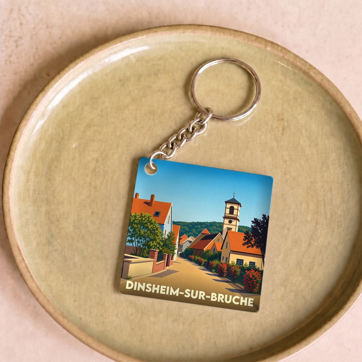 Porte-clés souvenir de la ville de Dinsheim-sur-Bruche avec une illustration stylisée.
