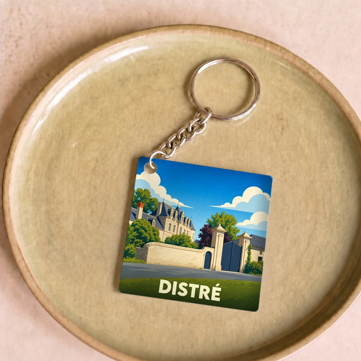 Porte-clés souvenir de la ville de Distré avec une illustration stylisée d'un château.