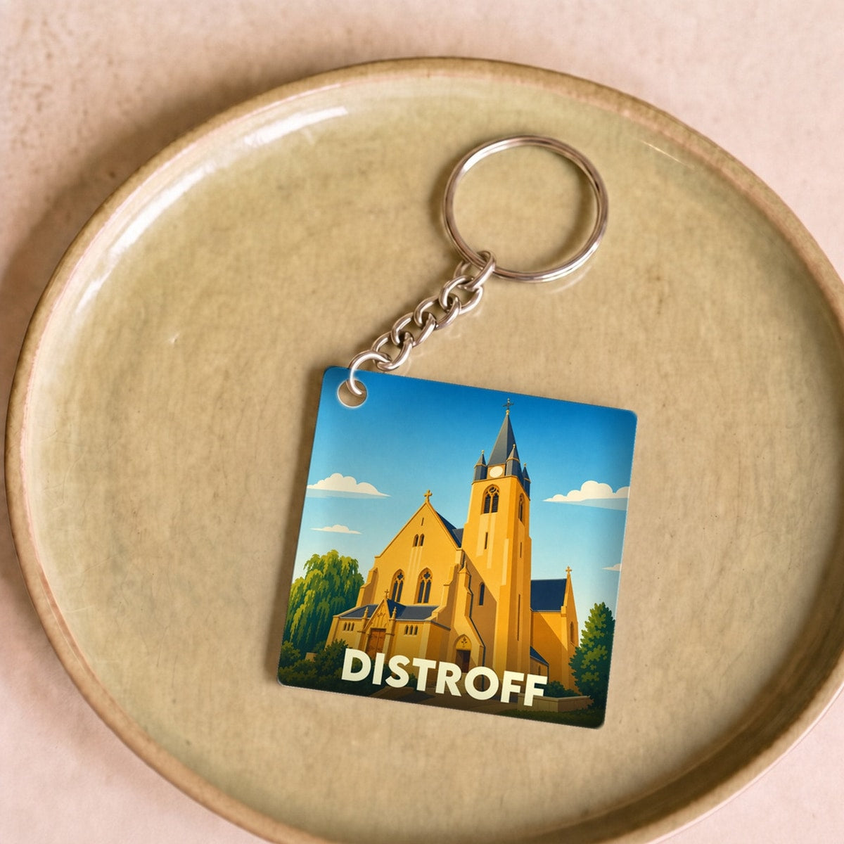 Porte-clés souvenir de la ville de Distroff avec une illustration stylisée de son église.
