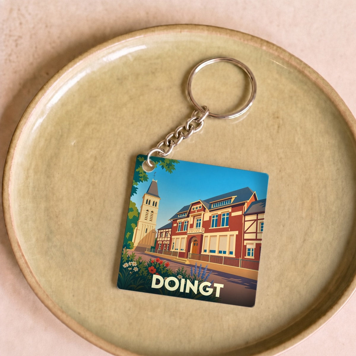 Porte-clés souvenir de la ville de Doingt avec une illustration stylisée.