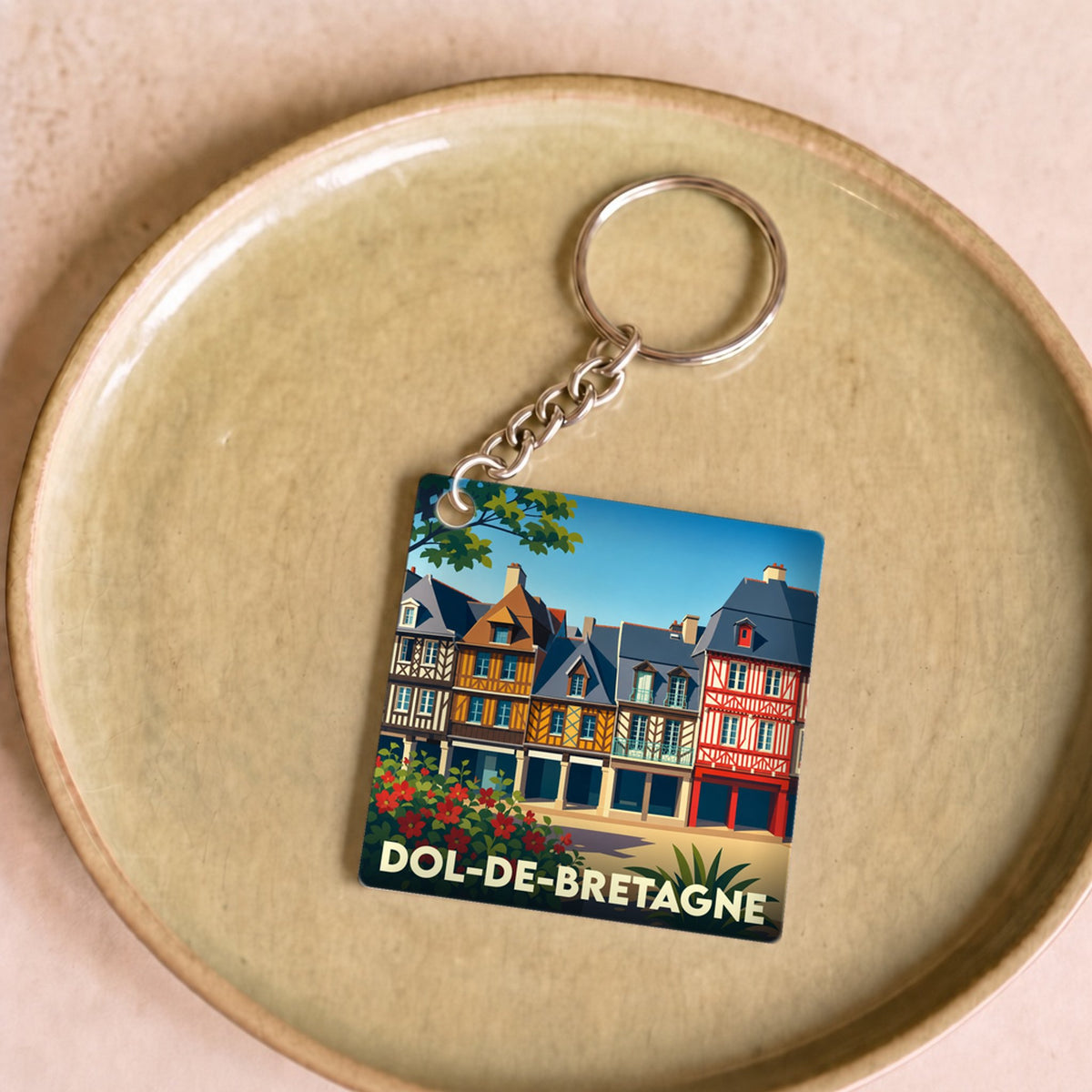 Porte-clés souvenir de la ville de Dol-de-Bretagne avec une illustration stylisée de ses maisons à colombages.