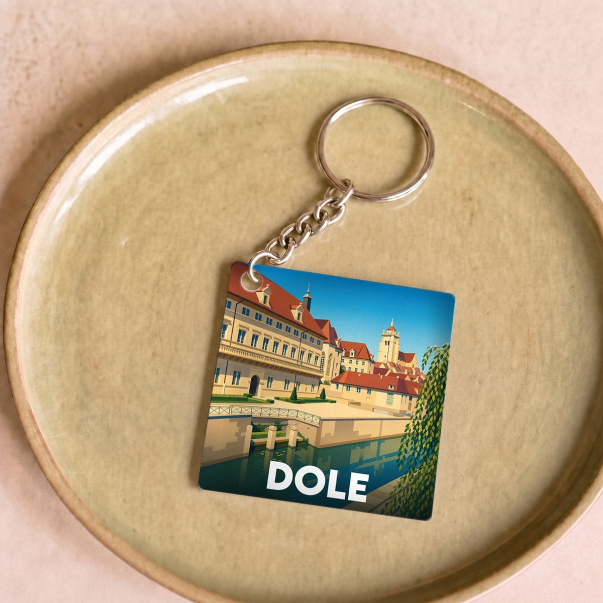 Porte-clés souvenir de la ville de Dole avec une illustration stylisée.