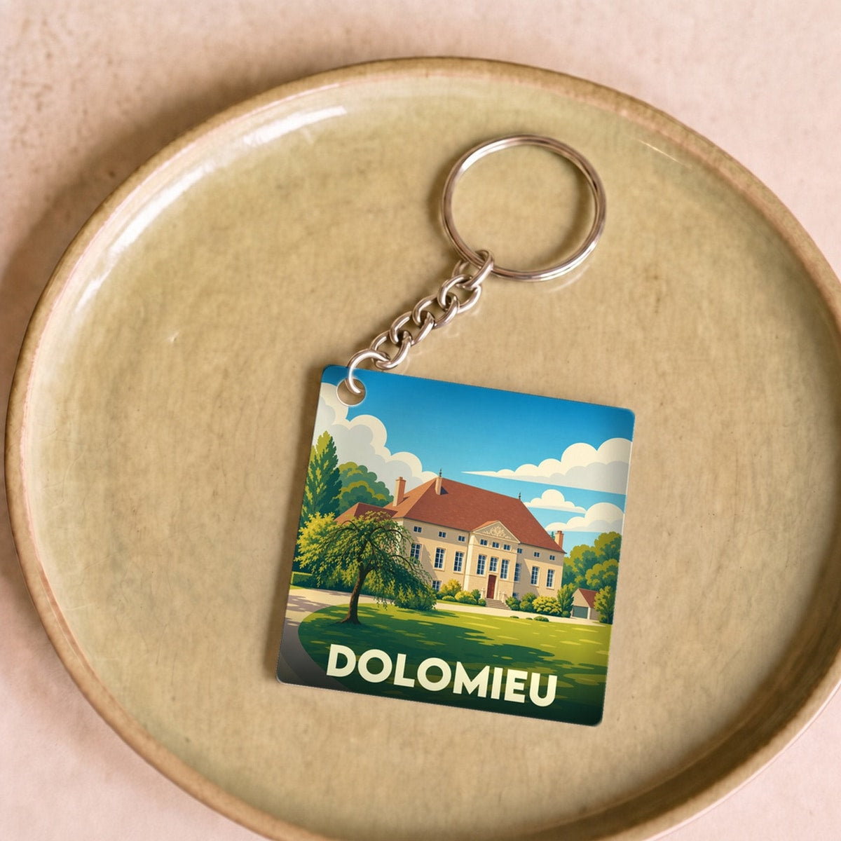 Porte-clés souvenir de la ville de Dolomieu avec une illustration stylisée d'une demeure bourgeoise.