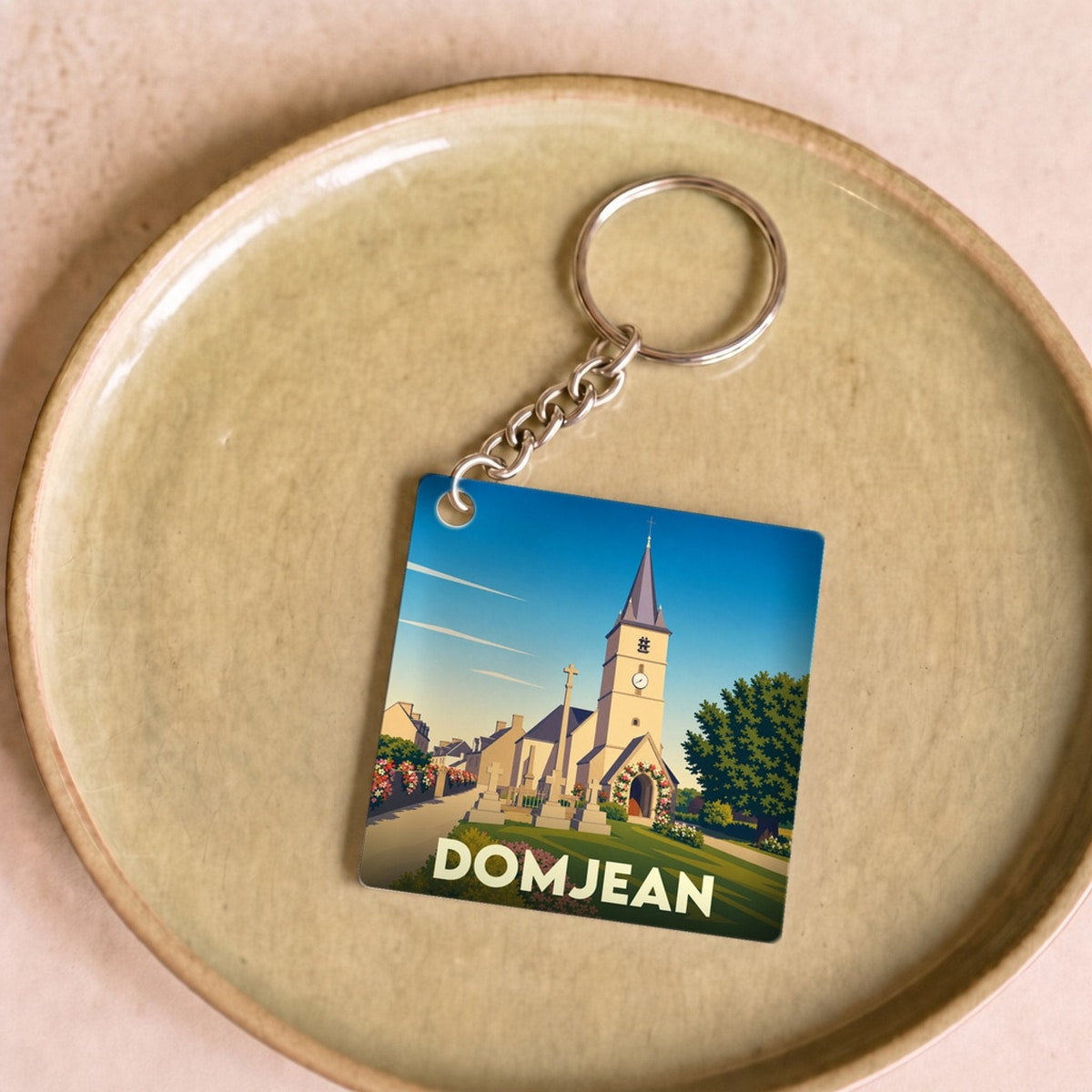 Porte-clés souvenir de la ville de Domjean avec une illustration stylisée de son église.