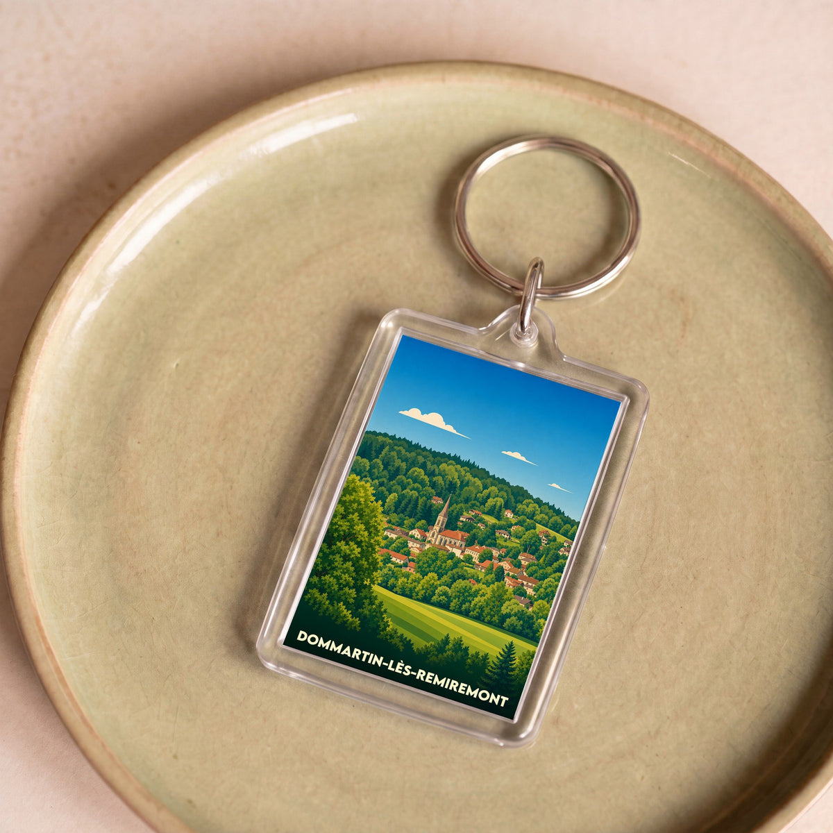 Porte-clés souvenir de la ville de Dommartin-lès-Remiremont avec une illustration stylisée.