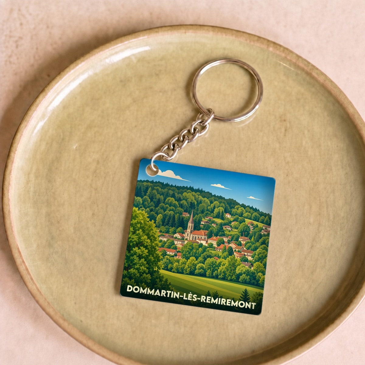 Porte-clés souvenir de la ville de Dommartin-lès-Remiremont avec une illustration stylisée.