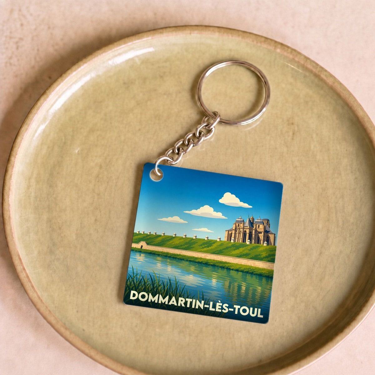 Porte-clés souvenir de la ville de Dommartin-lès-Toul avec une illustration stylisée.