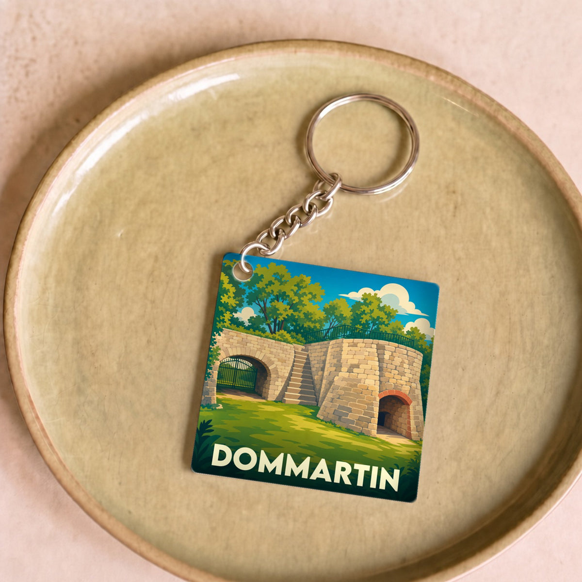Porte-clés souvenir de la ville de Dommartin avec une illustration stylisée.