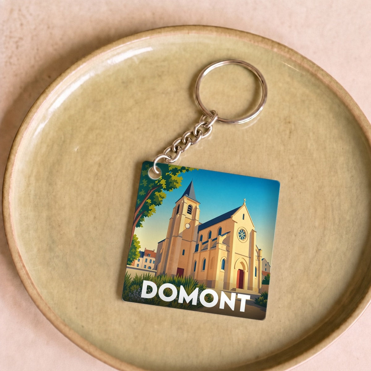 Porte-clés souvenir de la ville de Domont avec une illustration stylisée.