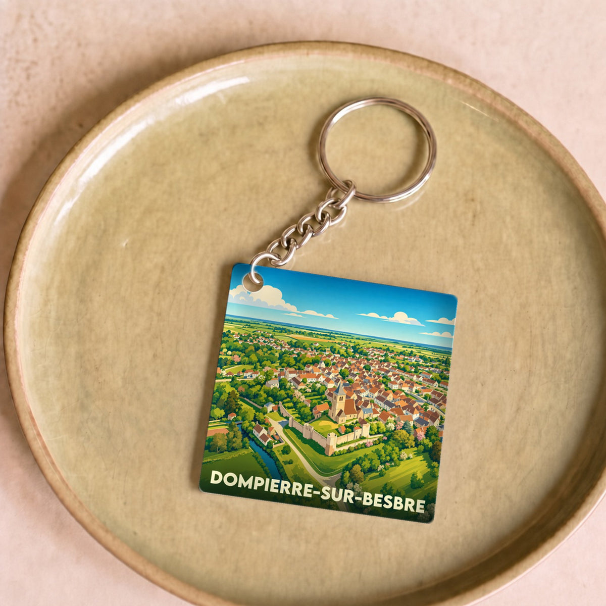 Porte-clés souvenir de la ville de Dompierre-sur-Besbre avec une illustration stylisée.