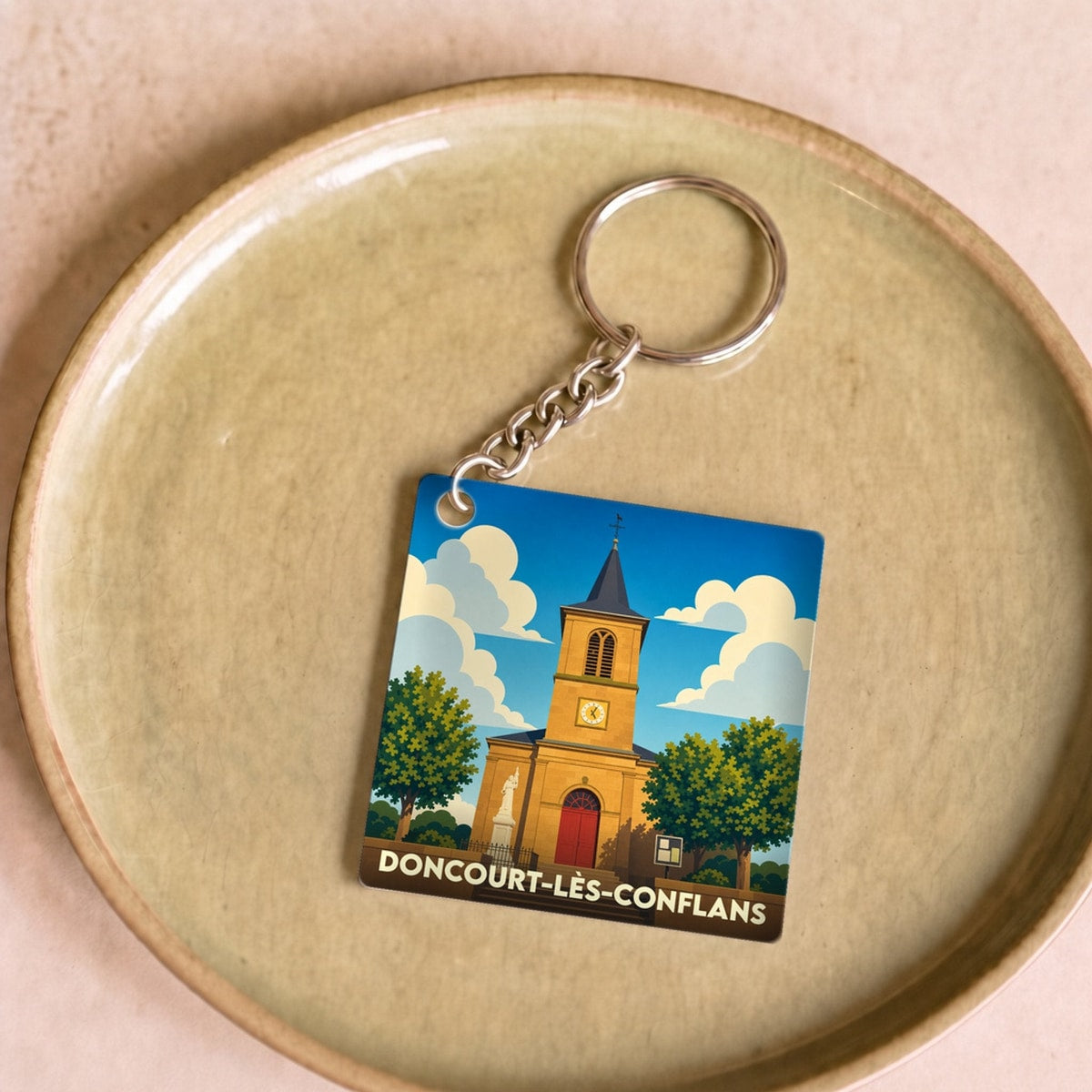 Porte-clés souvenir de la ville de Doncourt-lès-Conflans avec une illustration stylisée de son église.
