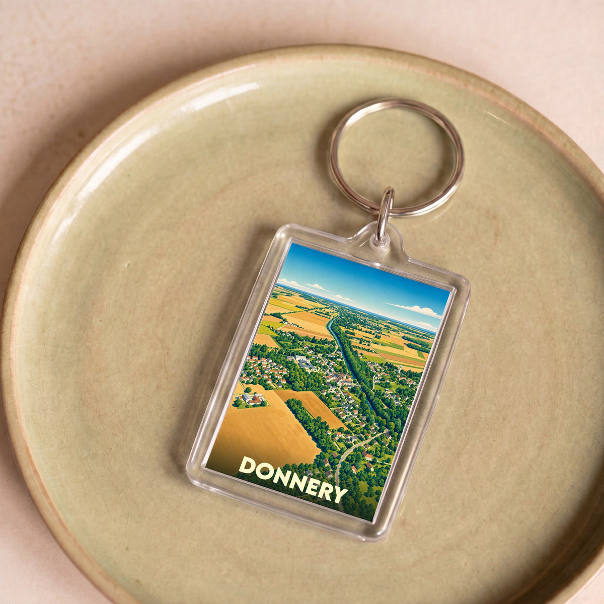 Porte-clés souvenir de la ville de Donnery avec une illustration aérienne stylisée.