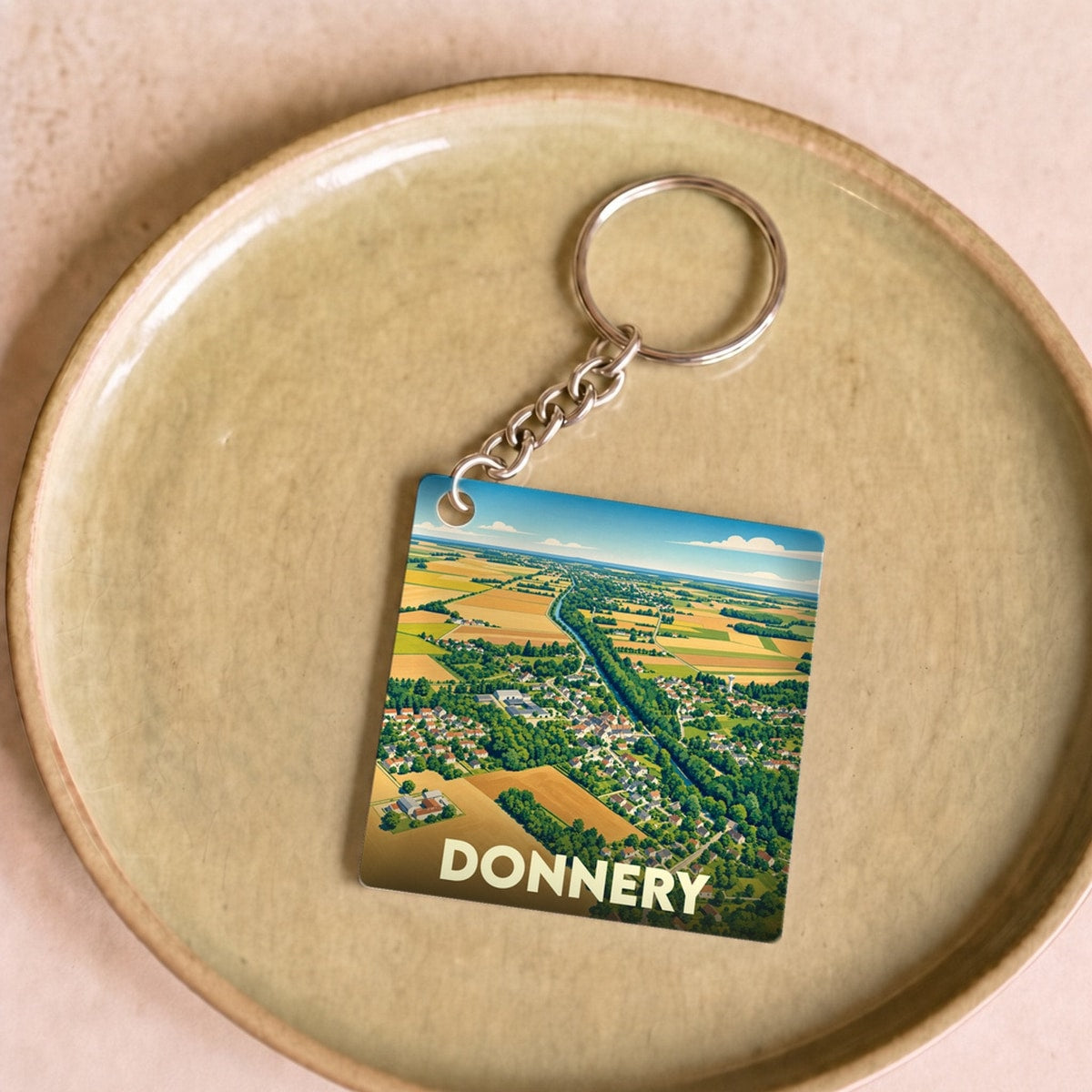 Porte-clés souvenir de la ville de Donnery avec une illustration aérienne stylisée.