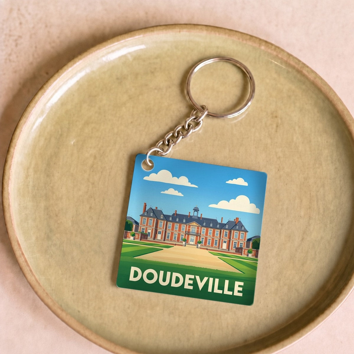 Porte-clés souvenir de la ville de Doudeville avec une illustration stylisée.