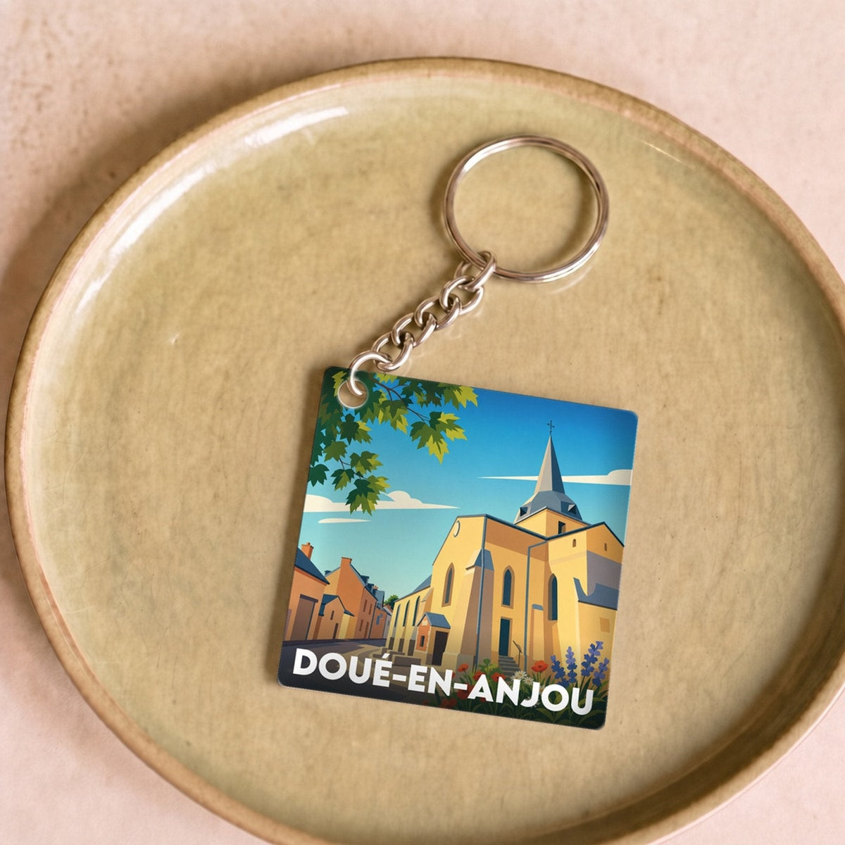 Porte-clés souvenir de la ville de Doué-en-Anjou avec une illustration stylisée.