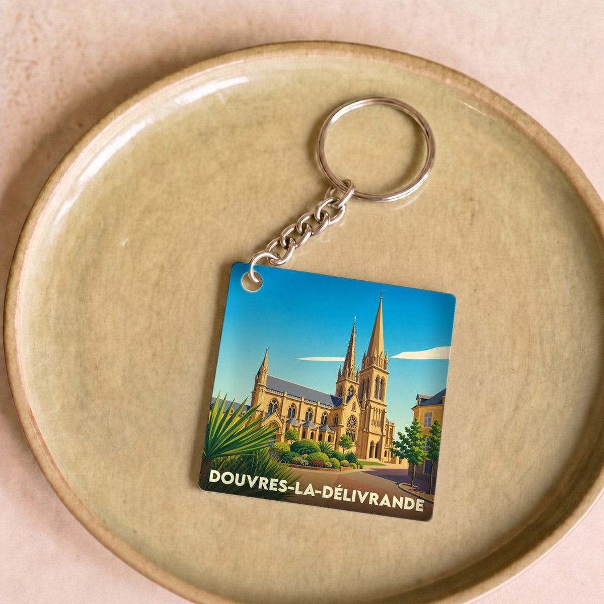Porte-clés souvenir de la ville de Douvres-la-Délivrande avec une illustration stylisée de sa basilique.