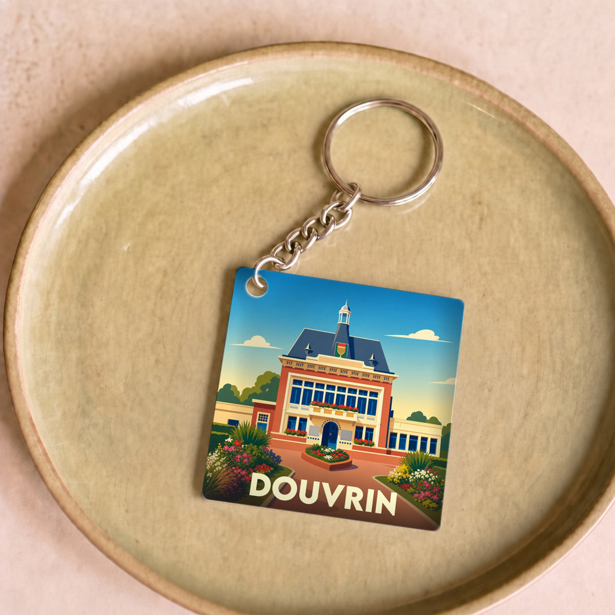Porte-clés souvenir de la ville de Douvrin avec une illustration stylisée de son hôtel de ville.