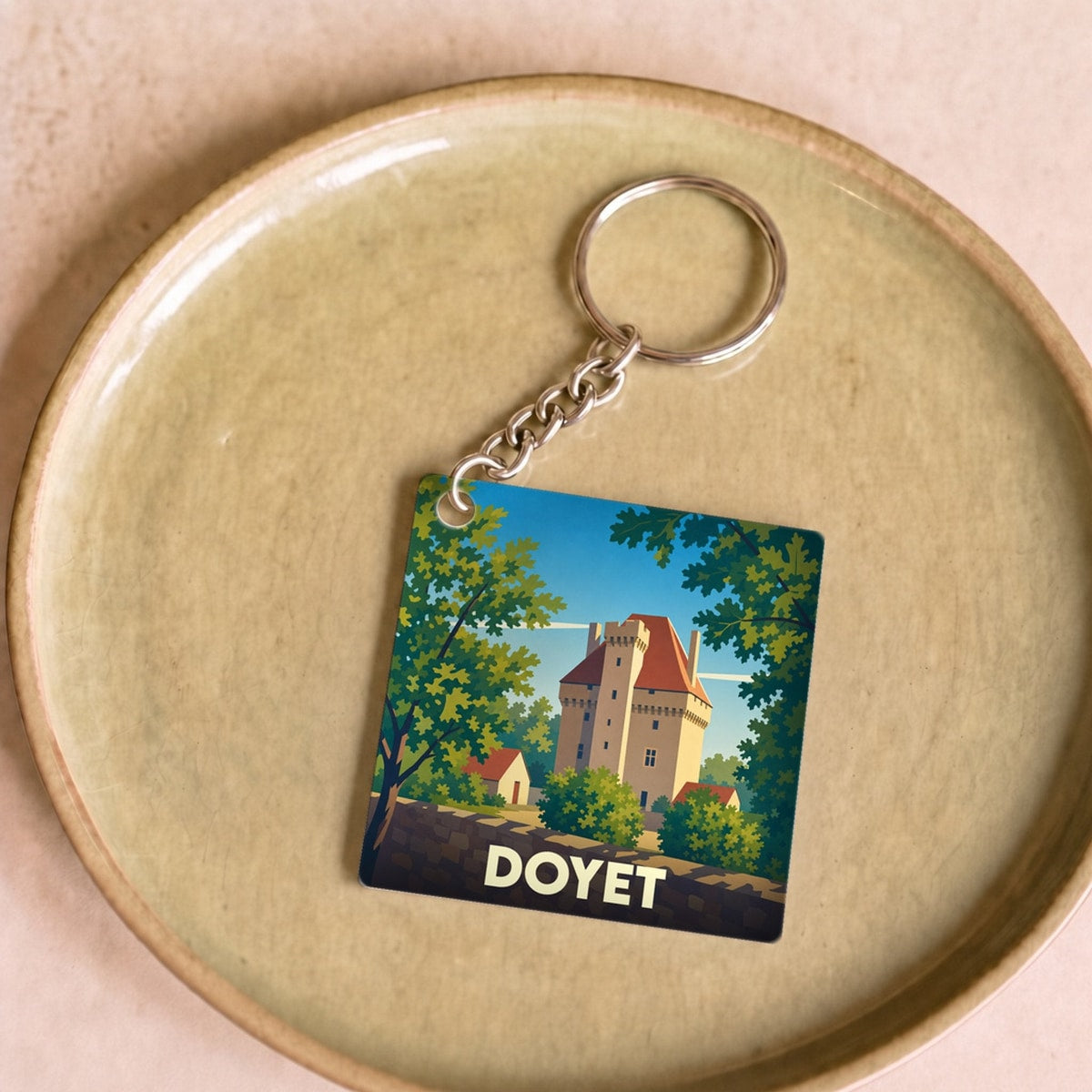 Porte-clés souvenir de la ville de Doyet avec une illustration stylisée d'un château.