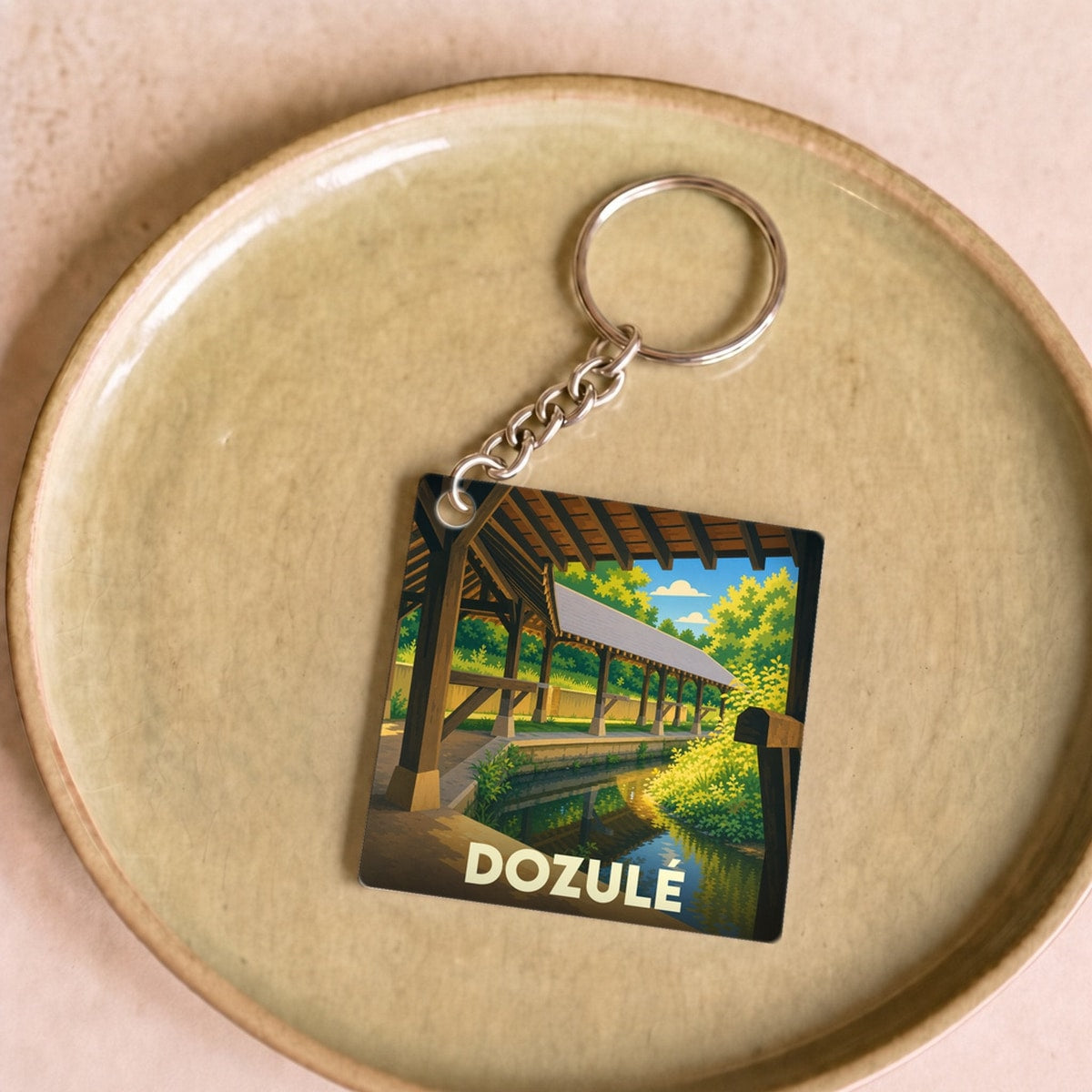 Porte-clés souvenir de la ville de Dozulé avec une illustration stylisée.