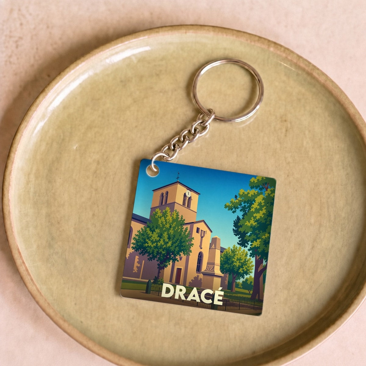 Porte-clés souvenir de la ville de Dracé avec une illustration stylisée de son église.