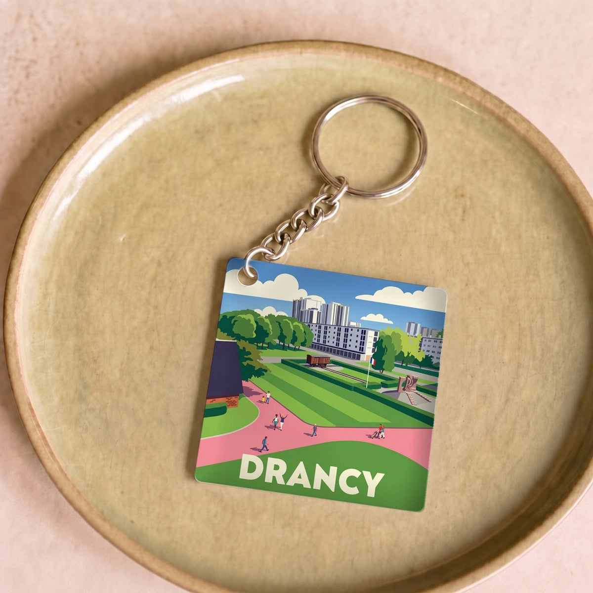 Porte-clés souvenir de la ville de Drancy avec une illustration stylisée.