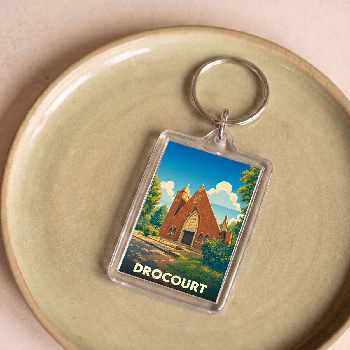 Porte-clés souvenir de la ville de Drocourt avec une illustration stylisée de son église.