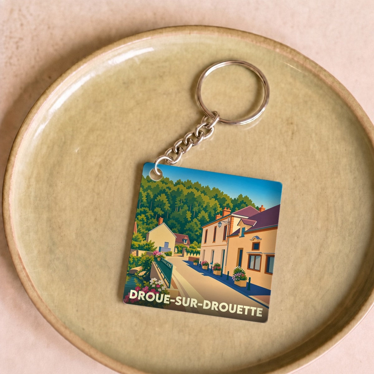 Porte-clés souvenir de la ville de Droue-sur-Drouette avec une illustration stylisée.