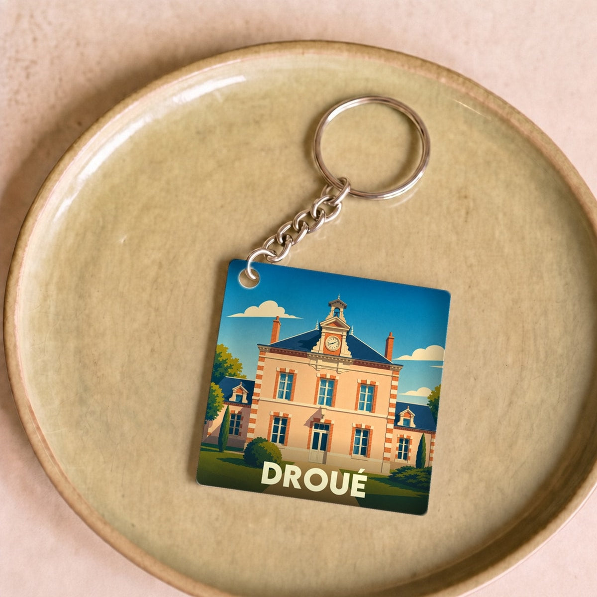 Porte-clés souvenir de la ville de Droué avec une illustration stylisée de sa mairie.