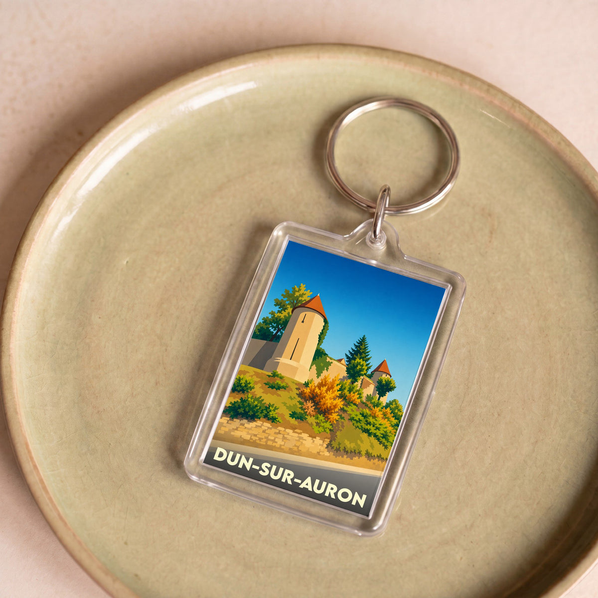 Porte-clés souvenir de la ville de Dun-sur-Auron avec une illustration stylisée de ses remparts.