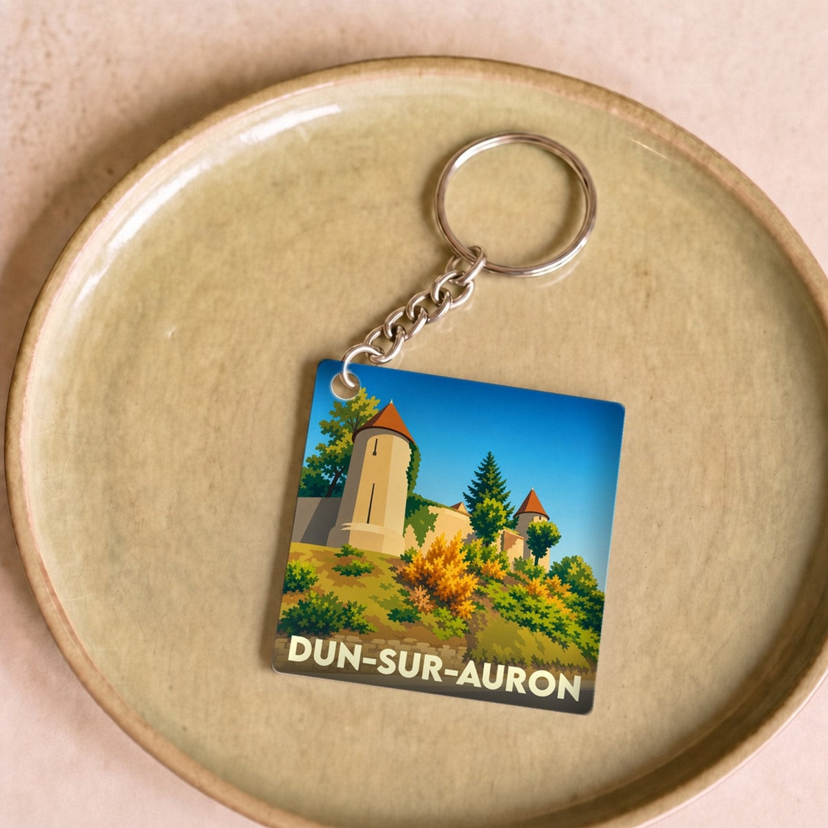 Porte-clés souvenir de la ville de Dun-sur-Auron avec une illustration stylisée de ses remparts.