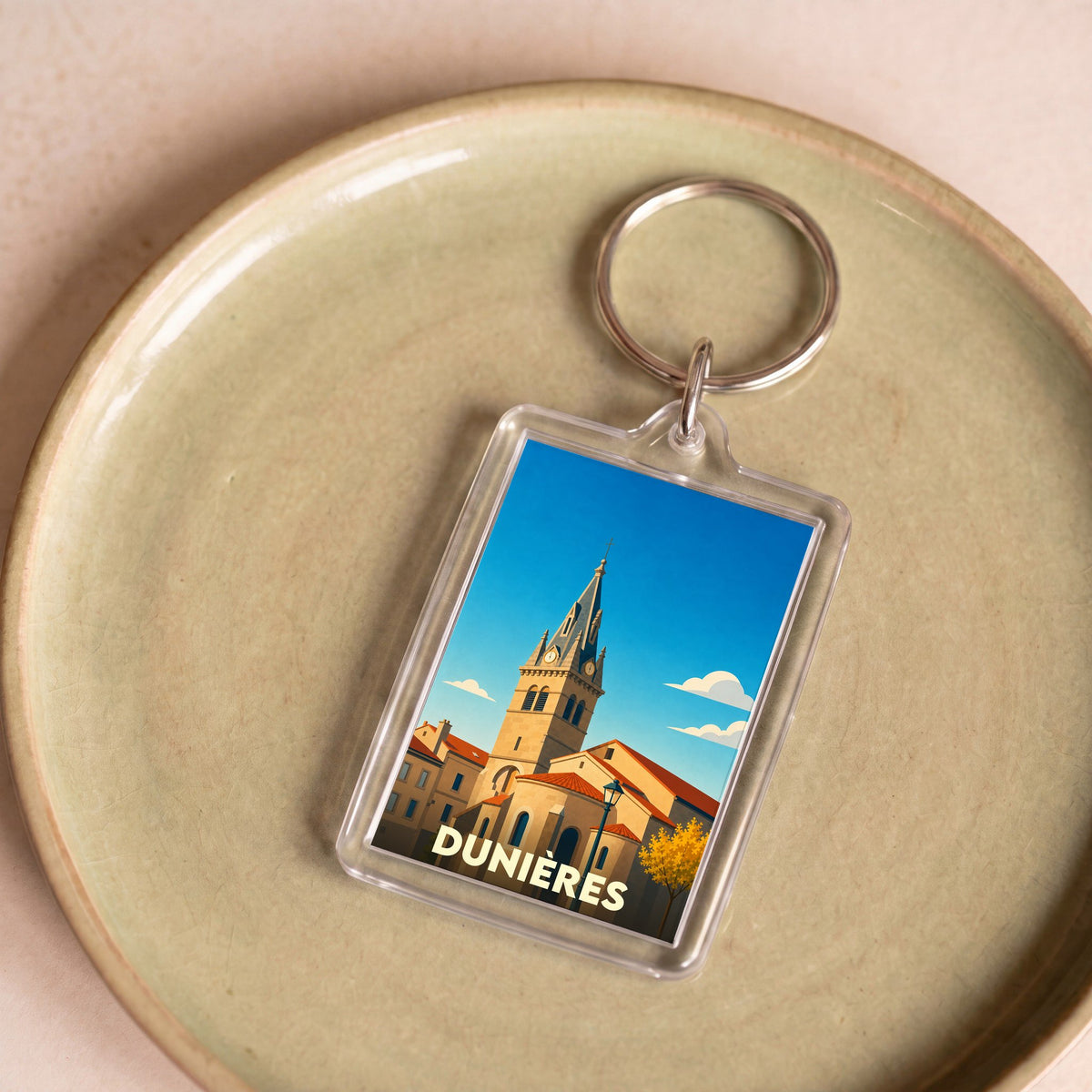 Porte-clés souvenir de la ville de Dunières avec une illustration stylisée de son église.