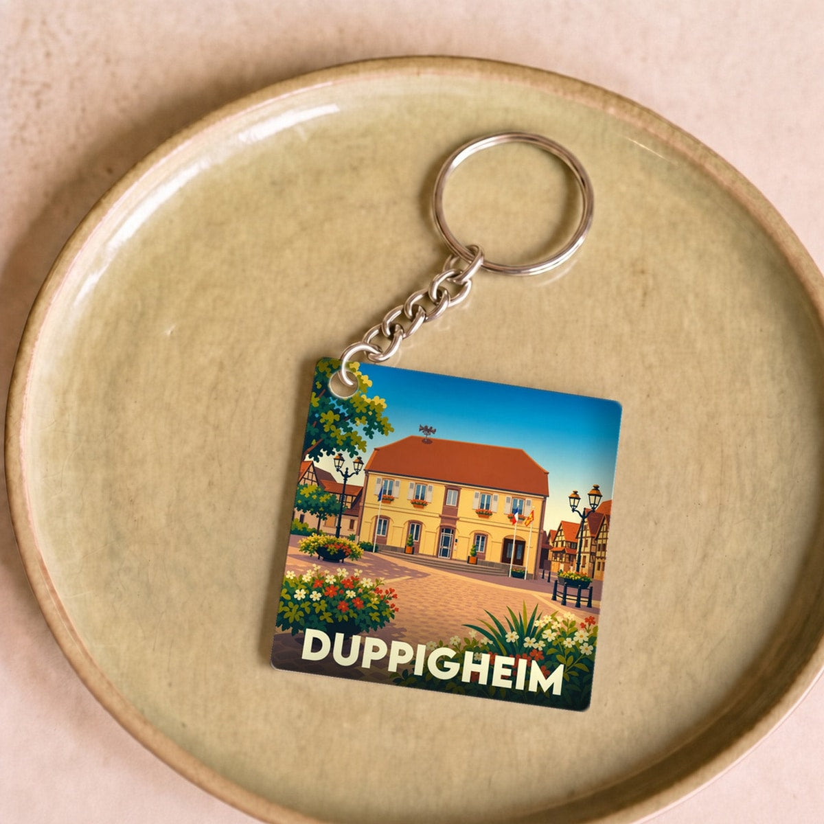 Porte-clés souvenir de la ville de Duppigheim avec une illustration stylisée.