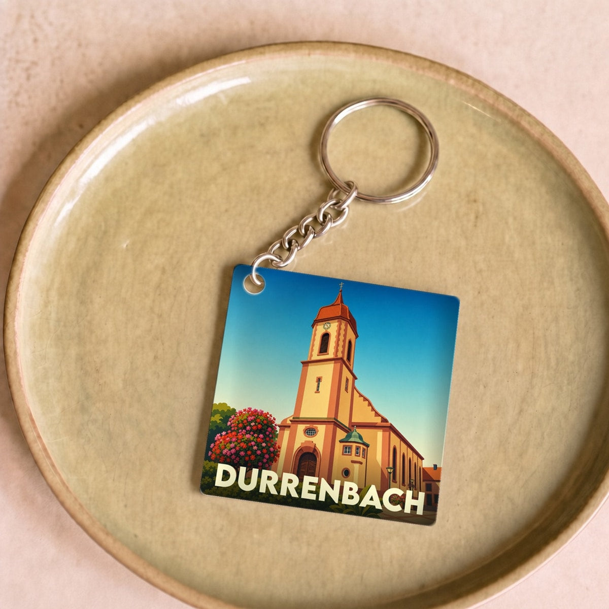 Porte-clés souvenir de la ville de Durrenbach avec une illustration stylisée de son église.