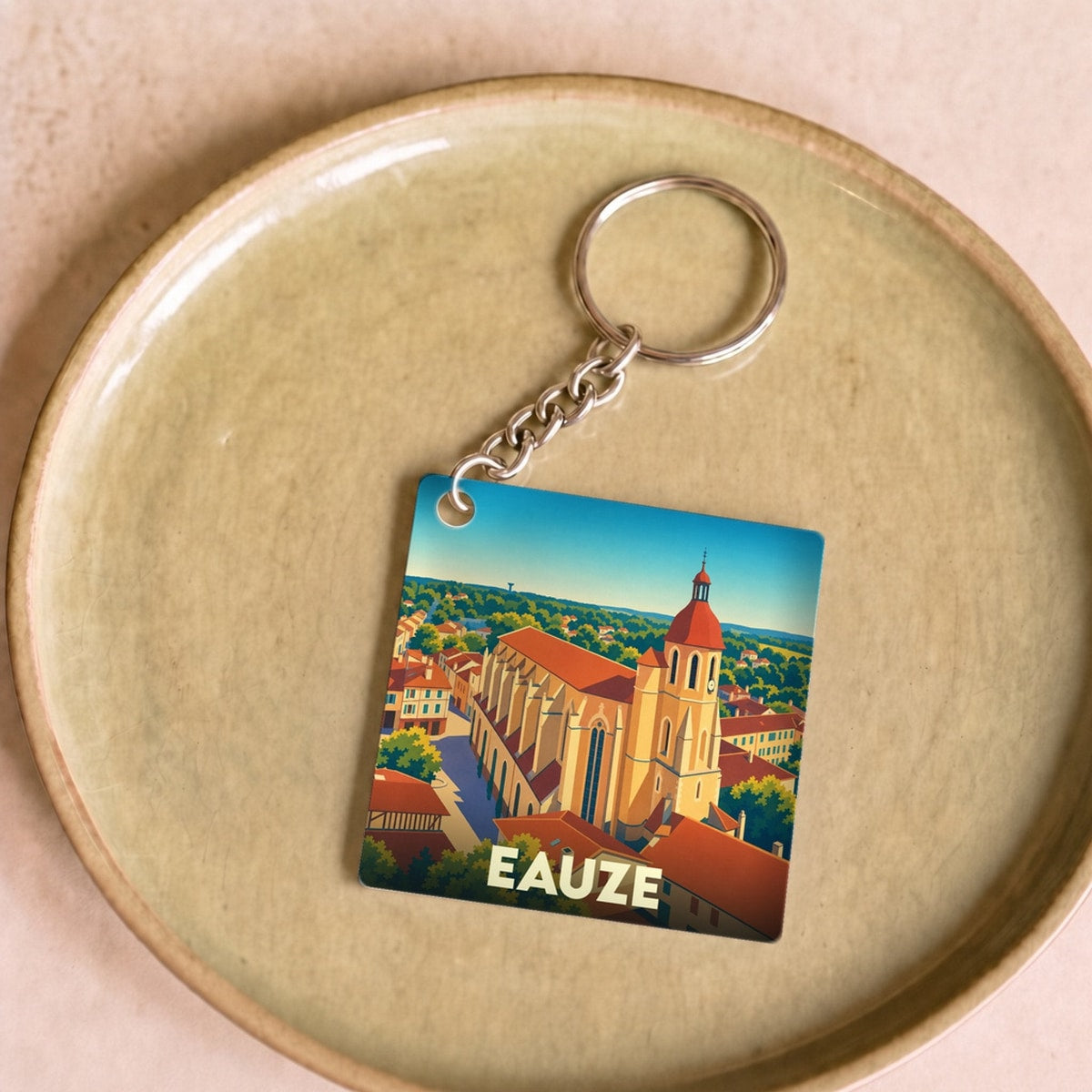 Porte-clés souvenir de la ville d'Eauze avec une illustration stylisée de sa cathédrale.