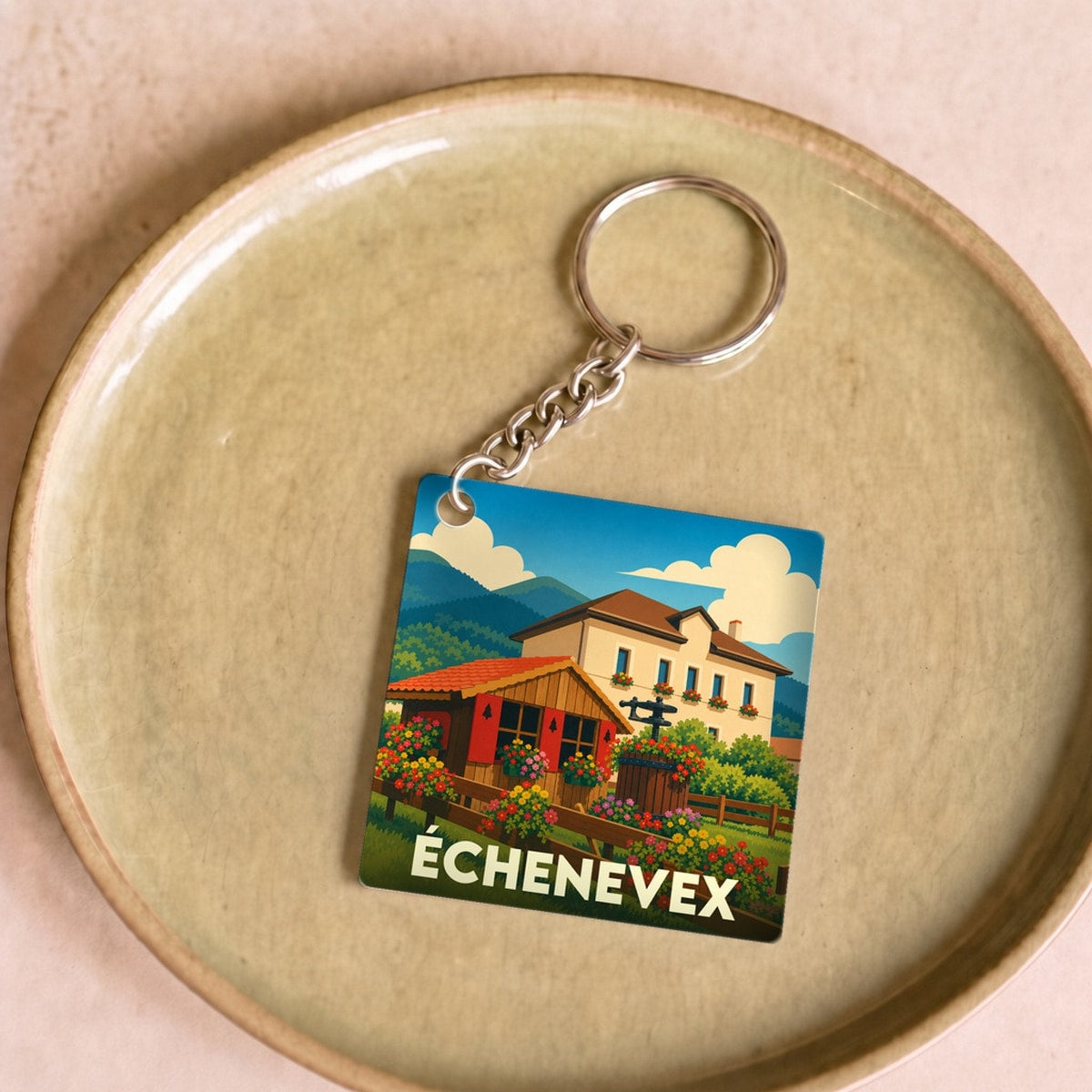 Porte-clés souvenir de la ville d'Échenevex avec une illustration stylisée d'un paysage de montagne.