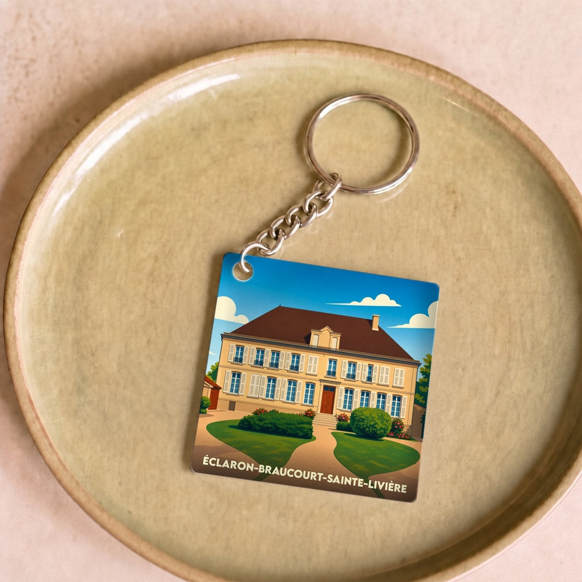 Porte-clés souvenir de la commune d'Éclaron-Braucourt-Sainte-Livière avec une illustration stylisée d'un manoir.